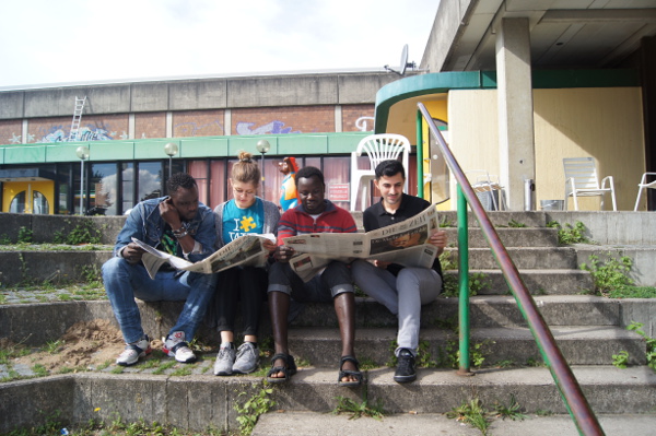 Studenten und Flüchtlinge lesen Zeitung